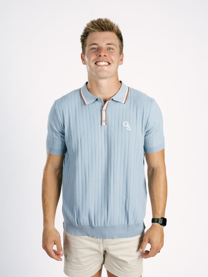 Light blue Georgia Southern men's ribbed polo shirt by Arena Graffiti with a "GS" logo, displayed on a mannequin.