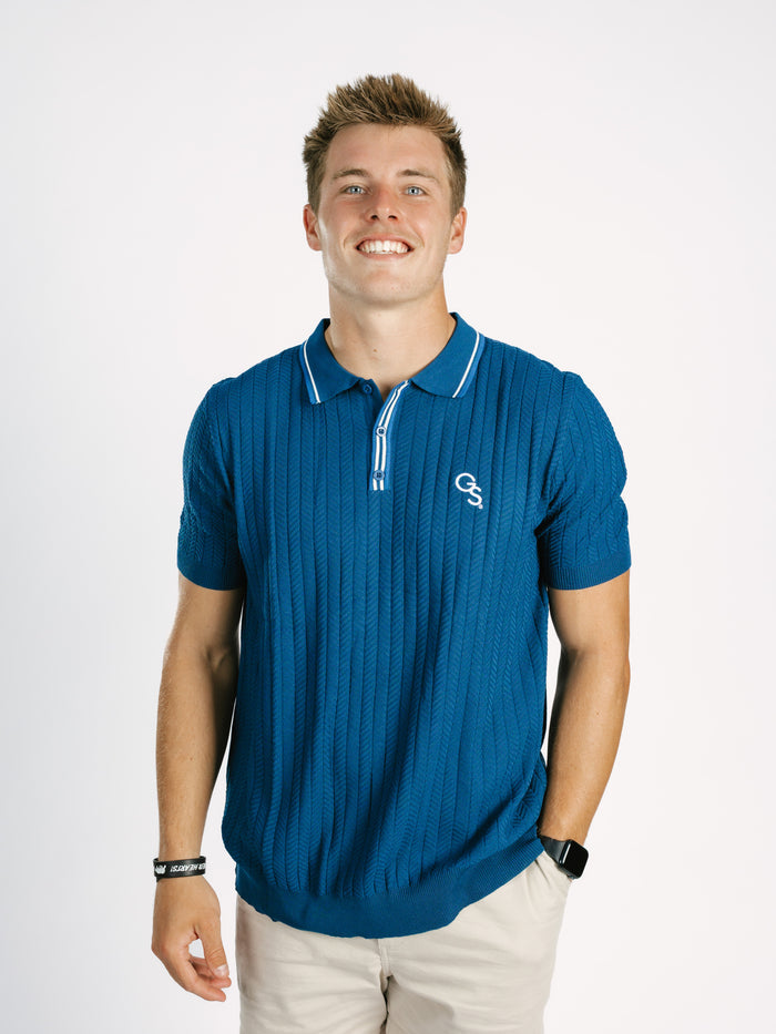 Navy Georgia Southern men's ribbed polo shirt by Arena Graffiti, featuring a "GS" logo on the chest, shown on a hanger.