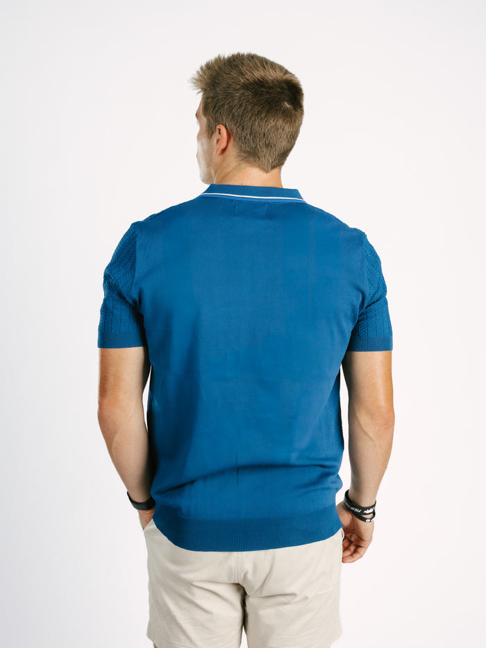 Navy Georgia Southern men's ribbed polo shirt with "GS" logo by Arena Graffiti, shown on a hanger against a white background.